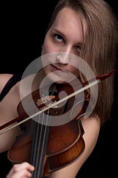 Passionate violin musician playing on black background