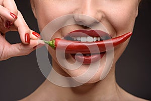 Passionate woman eating hot chili