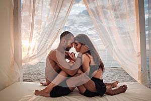 Passionate young couple sitting on the beach photo