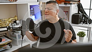 Passionate young latin man, a confident musician, performing his melody, singing and dancing in a music studio, joyfully