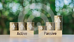 Passive income and Active income on stack coins with arrow sign. Financial freedom concept.Investment business stock growth.