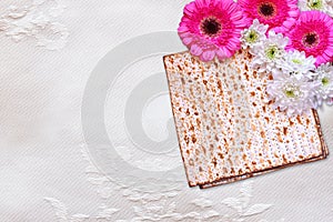 Passover background. matzoh (jewish passover bread) and flowers on white table cloth