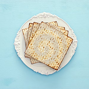 passover background with matzoh over light blue wooden background.