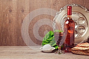 Passover background with wine bottle, matzoh, egg and seder plate