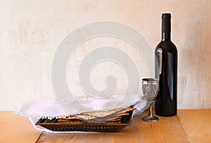 Passover background. wine and matzoh (jewish passover bread) over wooden background