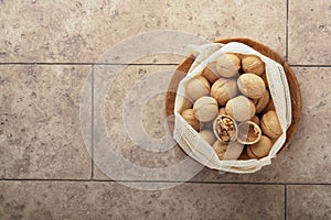 Passover celebration concept. Organic walnuts in eco bags on old grey cracked tile countertop table background. Passover food.