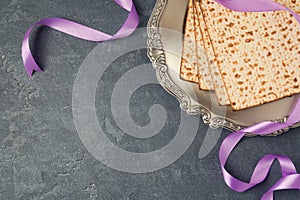 Passover holiday concept with seder plate and matzoh on dark background.