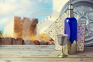 Passover matzo and wine on wooden vintage table over old city walls. Seder plate with hebrew text