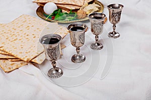 Passover matzoh jewish holiday bread, four glasses kosher wine over wooden table photo