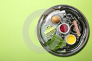 Passover Seder plate keara with symbolic meal on green background, top view. Pesah celebration