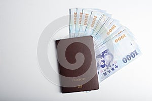 Passport and 1000 New Taiwan Dollar bill on white background