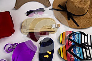 Passport in a belt bag. Flip flops, safety goggles and straw hat, airplane inflatable pillow, sleep mask and in-flight