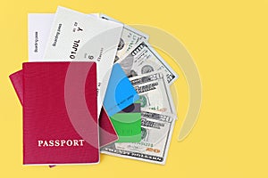 Passport, boarding pass, flight ticket, cash money currency, us dollars, credit card yellow background closeup top view, travel