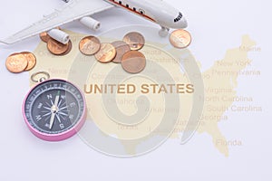 Passport compass and coins on a American map. business travel concept