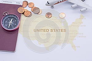 Passport compass and coins on a American map. business travel concept