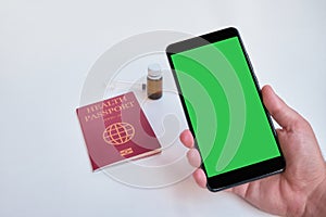 Passport and hand holding smart phone with green screen.Travel concept with copy space. chroma key mockup