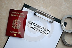 Passport of Italy and Extradition Agreement with handcuffs on table