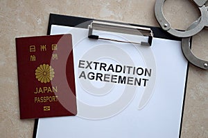 Passport of Japan and Extradition Agreement with handcuffs on table