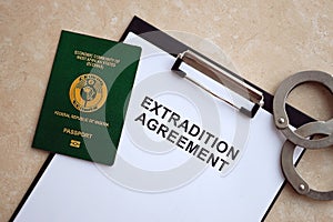 Passport of Pakistan and Extradition Agreement with handcuffs on table