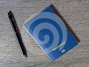 Passport with with pen on dark wooden background