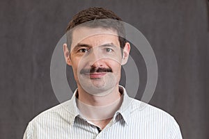 Passport photo of a smiling forties man with a mustache