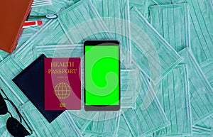 Passport and smart phone with green screen.Travel concept with copy space. Medical mask backgroound,chroma key mockup