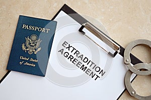 Passport of United States and Extradition Agreement with handcuffs on table