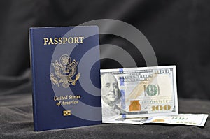 Passport of a US citizen with embedded US dollar banknotes on a dark background. Identification.