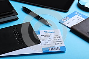 Passports with avia tickets on light blue background, closeup. Travel agency concept