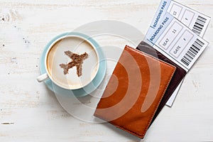 Passports, boarding pass and cup of coffee (airplane made of cinnamon)