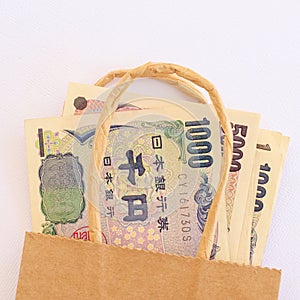 Japanese yen currency in a brown paper bag..