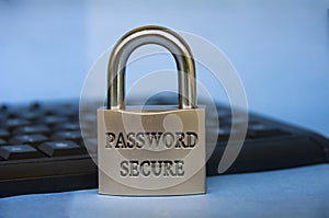 Password secure text engraved on padlock with blurred keyboard background. Password security concept