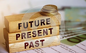 Past Present Future words written on wood block. 100 Euro banknotes and coins. Investment and saving for future planning career