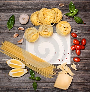 Pasta background with ingredients for cooking around paper