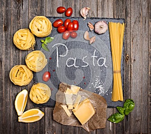 Pasta background with ingredients for cooking on slate board, to