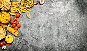 Pasta background. Various pasta with spices and vegetables.