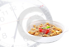 Pasta with basil and tomato sauce with clock on background
