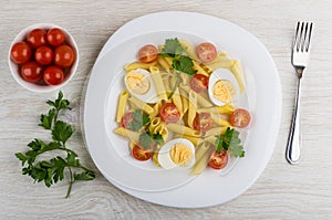 Pasta with eggs, tomatoes, parsley, fork, parsley, tomato cherry