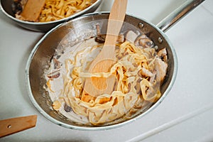 Pasta boiling in a pan on white table