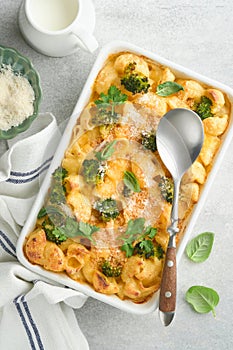 Pasta Broccoli casserole. Baked Mac and cheese with broccoli, cream sauce and parmesan on gray light concrete table background