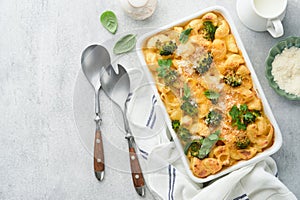 Pasta Broccoli casserole. Baked Mac and cheese with broccoli, cream sauce and parmesan on gray light concrete table background