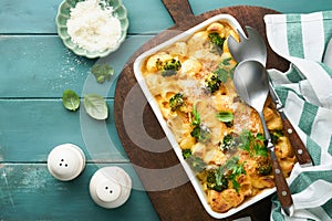 Pasta Broccoli casserole. Baked Mac and cheese with broccoli, cream sauce and parmesan on old rustic wooden background