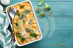 Pasta Broccoli casserole. Baked Mac and cheese with broccoli, cream sauce and parmesan on old rustic wooden background. Healthy or