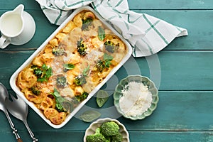 Pasta Broccoli casserole. Baked Mac and cheese with broccoli, cream sauce and parmesan on old rustic wooden background. Healthy or