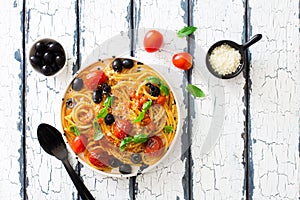 Pasta bucatini with tomato sauce, tomatoes, black olives and parmesan cheese
