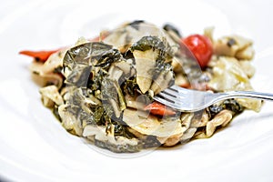 Pasta called maltagliati with turnip greens, and cherry tomatoes