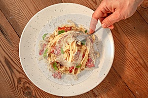 Pasta Carbonara with bacon and parmesan in a plate. Homemade egg pasta tagliatelle Wooden background. Top view. Copy