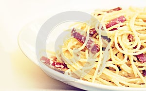 Pasta carbonara spaghetti with ham, bacon and fresh parmesan on the white plate in restaurant in Catania, Sicily, Italy