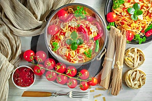 Pasta in a composition with accessories on the table, on an old background.