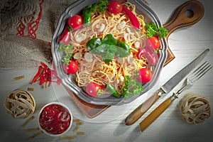 Pasta in a composition with accessories on the table, on an old background.